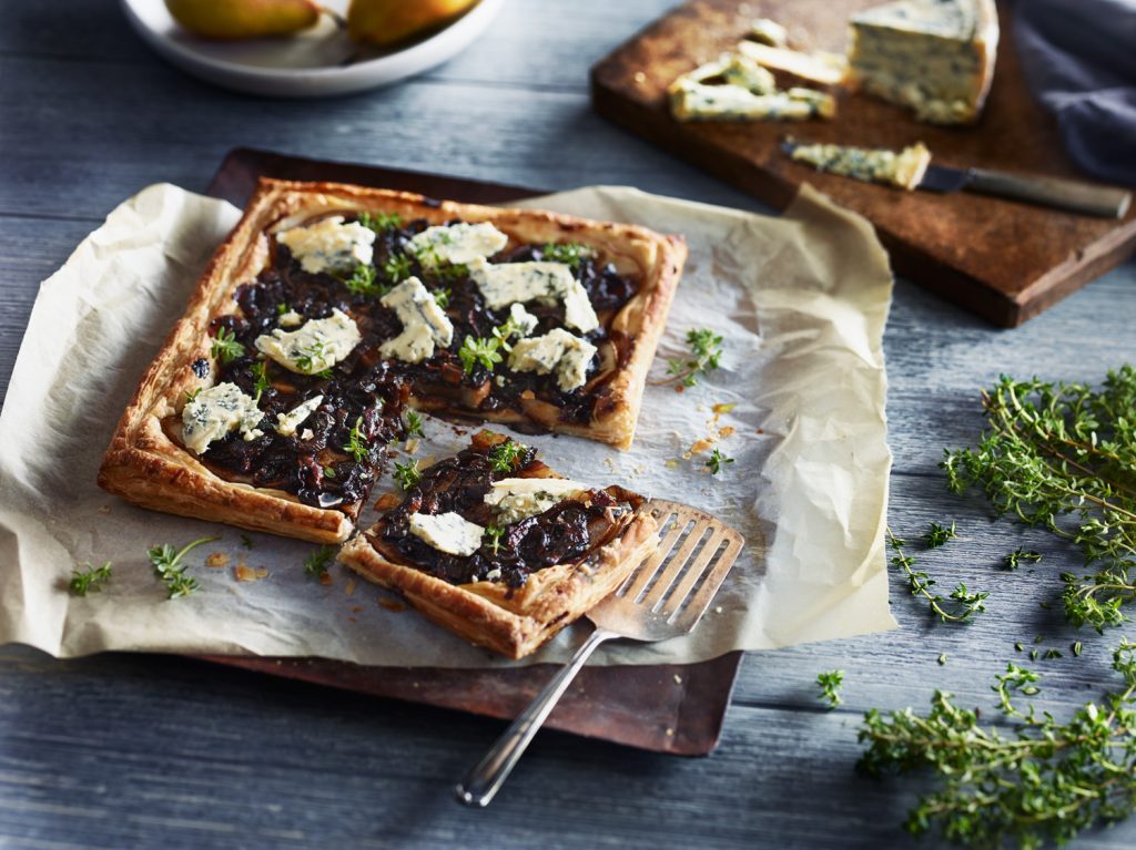 Savoury tart with caramelised balsamic onions, blue cheese and pear, featuring balsamic vinegar and premium olive oil.