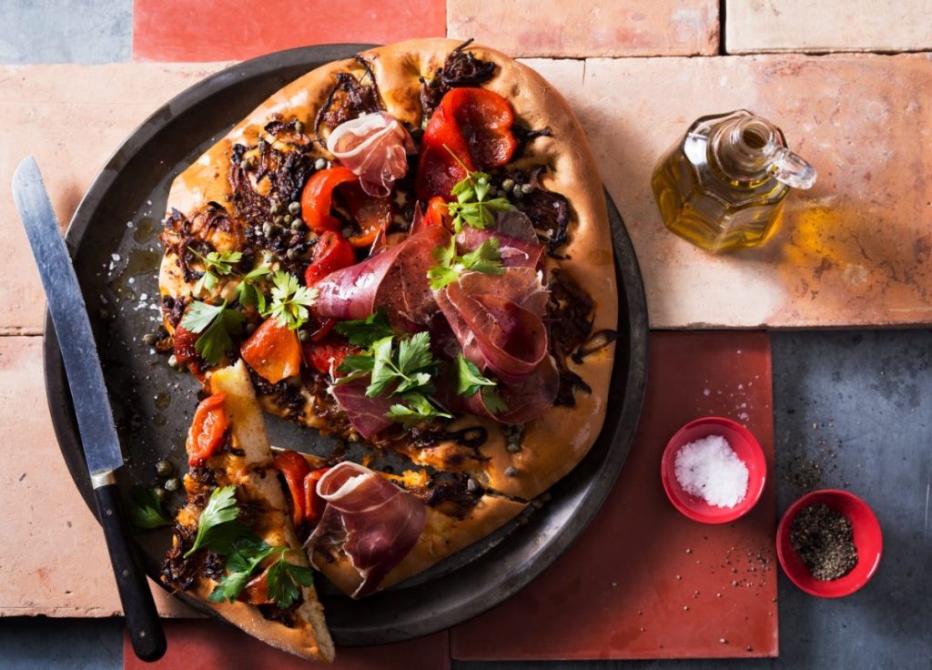 Golden-baked Spanish flatbread topped with roasted red capsicum, tomato, caramelised onion, and anchovies.