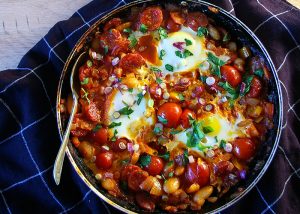 Spanish-style baked eggs with chickpeas and Mediterranean olive oil, perfect for a healthy olive oil recipe.
